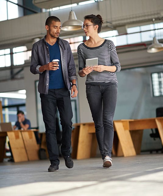 Scion Staffing Team members deep in work discussions while walking and drinking coffee